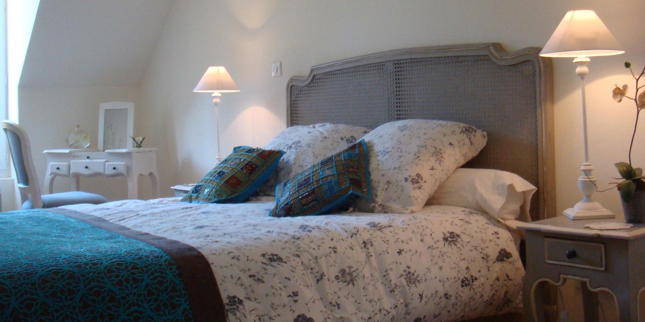 Chambre d'hôtes du Manoir Saint-Hubert, lit à tête de lit cannée et lampes de chevet allumées