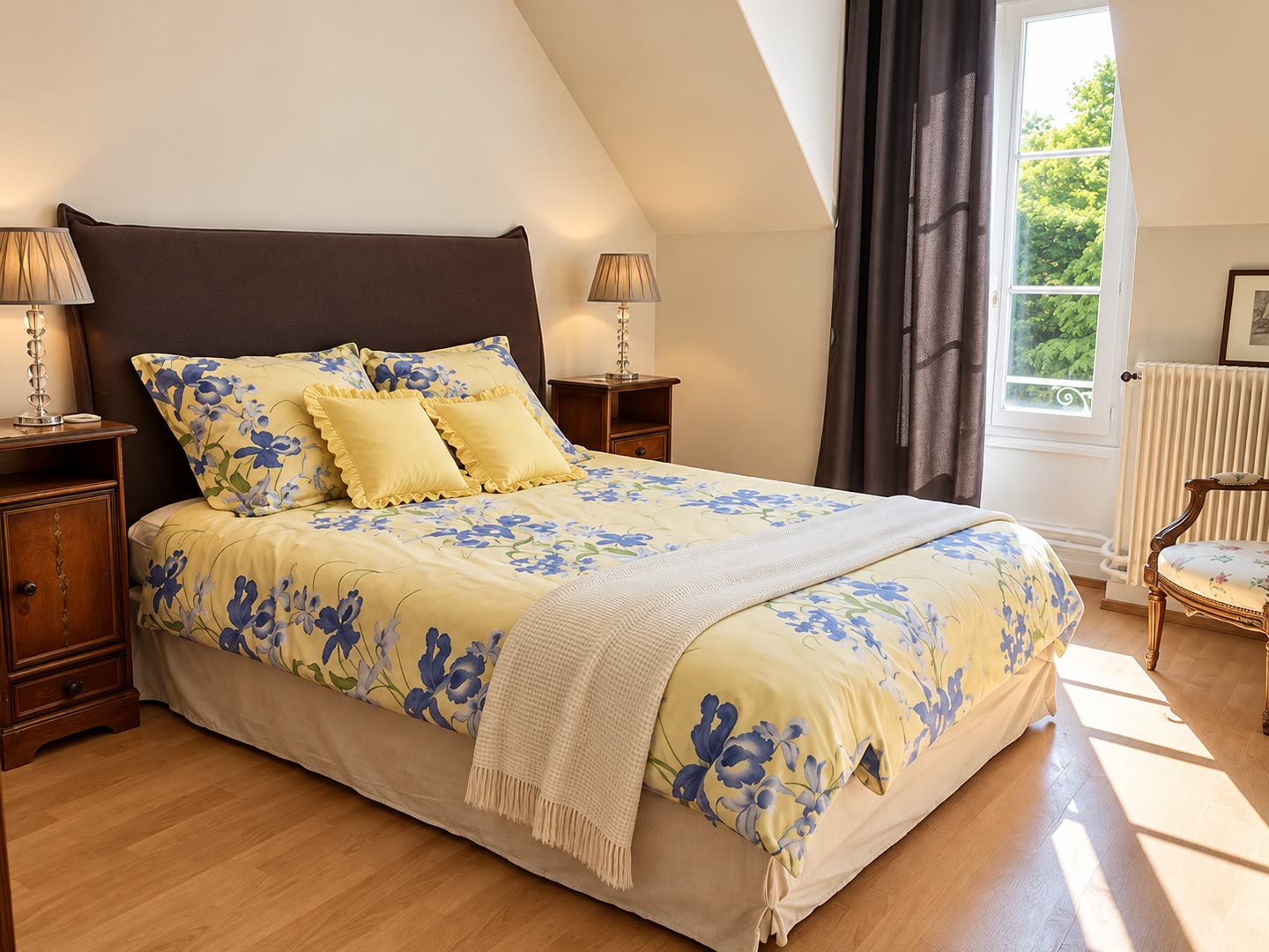 Une chambre du gîte, lit double sous la pente du toit et fenêtre ouverte sur le parc