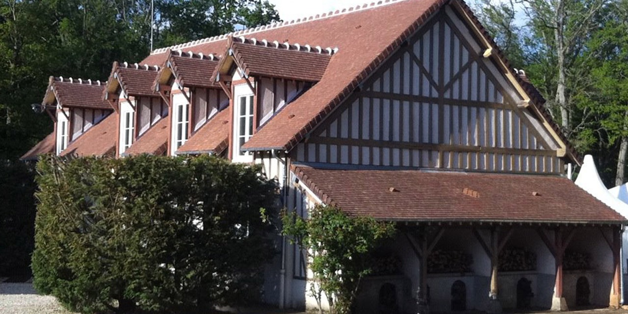Les bâtiments à colombages du domaine, avec leurs lucarnes de tuiles
