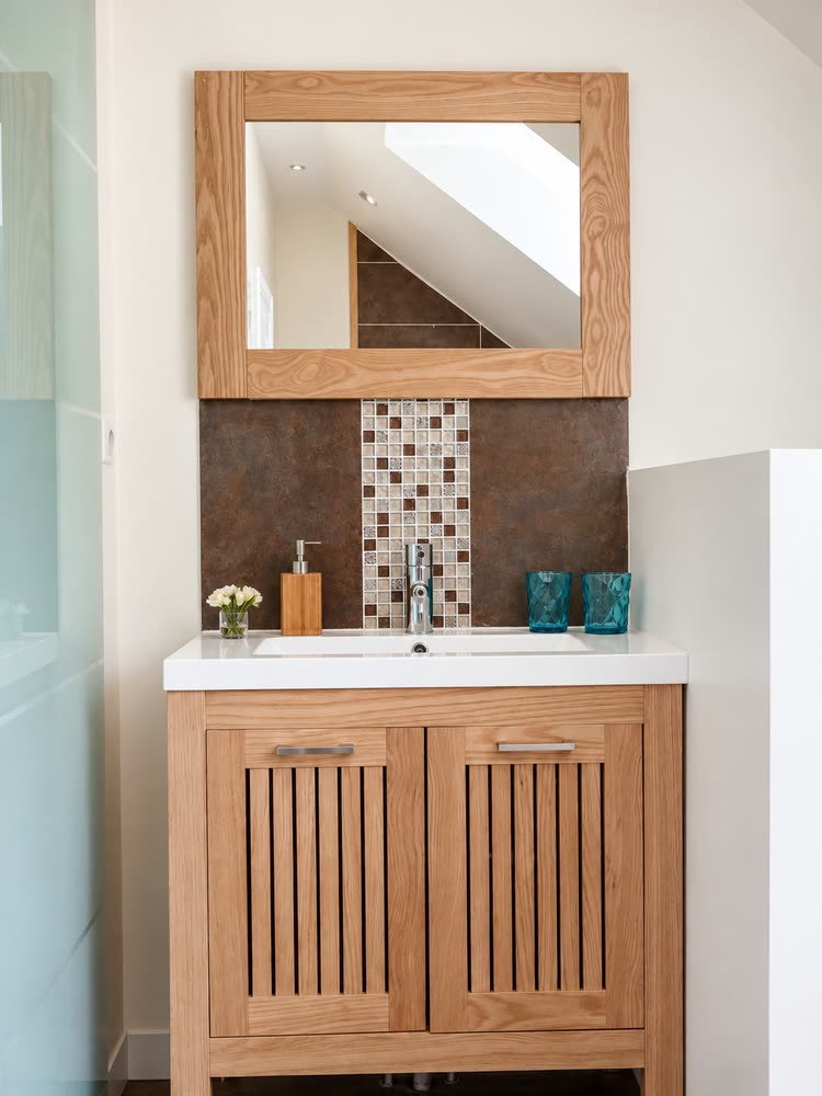 La salle de bain de la Suite Nuptiale, vasque sur meuble de bois et miroir encadré