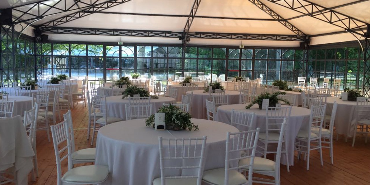 L'orangerie dressée en tables rondes pour un mariage